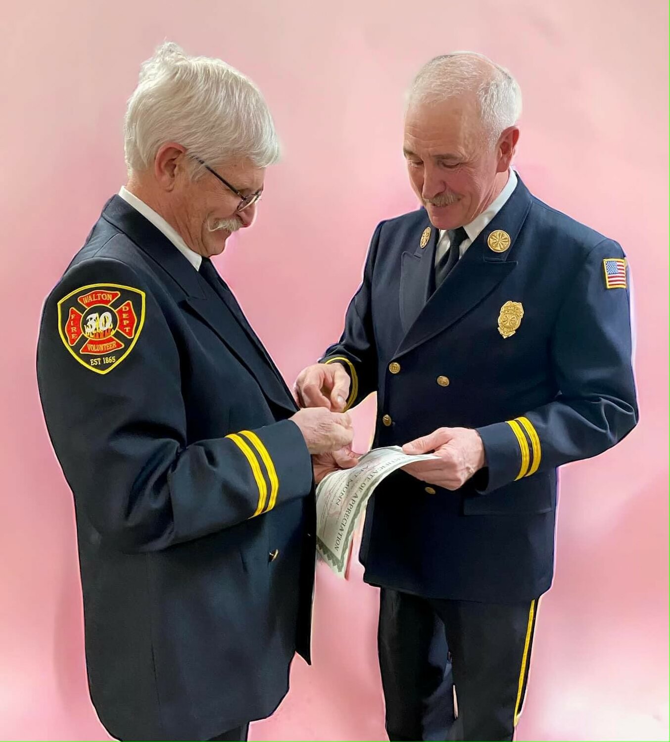 Art Munn, left, was presented with an award for 50 years of service by Walton Fire Chief Bob Brown, Feb. 17.